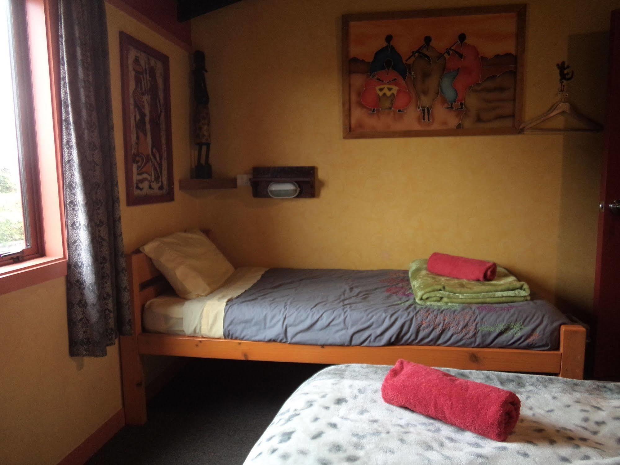 그레이마우스 글로벌 빌리지 트래블러스 로지 호스텔 외부 사진 A single bed in a hostel room